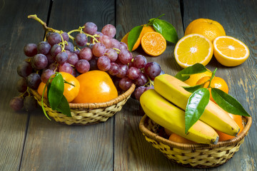 composition of fresh fruits in wicker baskets on a wooden backgr