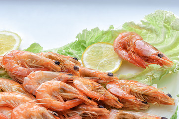 Close-up of shrimp on lettuce leaves with seasoning and lemon on