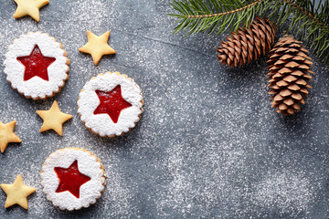 Linzer star cookies with jam filling with fir tree cone decorations flat lay traditional Christmas homemade Austrian sweet dessert food Xmas celebration pastry holiday snack on vintage background.
