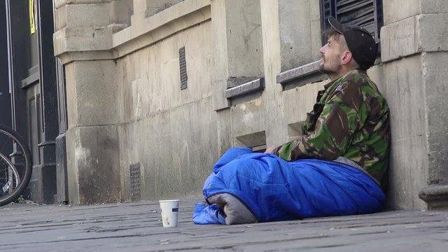 homeless man waiting for charity in the street 
