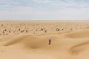 Fototapeta na wymiar Man tourist desert rub al khali Oman running in sand 2