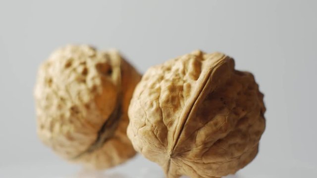 Macro pile of walnuts isolated on white, rotates around.