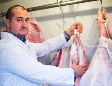 butcher working with meat in store.