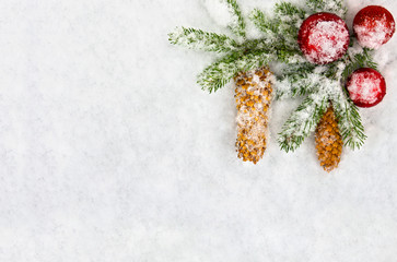 Christmas decoration. Branch christmas tree, christmas balls and cones spruce on snow. Top view, flat lay