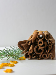 Cinnamon sticks and powder on rustic wooden board, top view