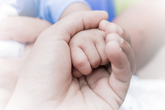 Closeup of a baby hand in hand father