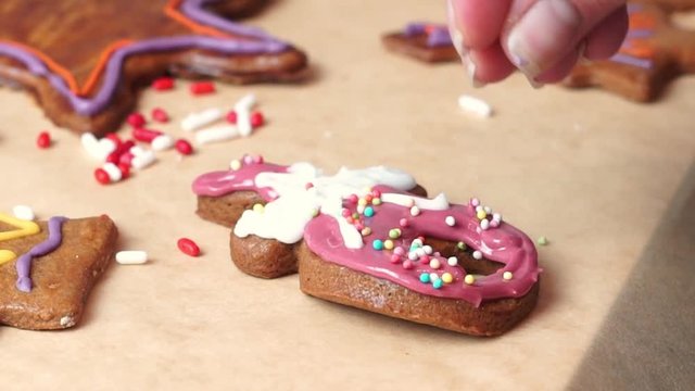 women decorating gingerbread with edible sugar sprinkles