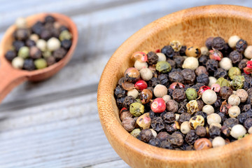 Colorful peppercorns in a bowl and spoon