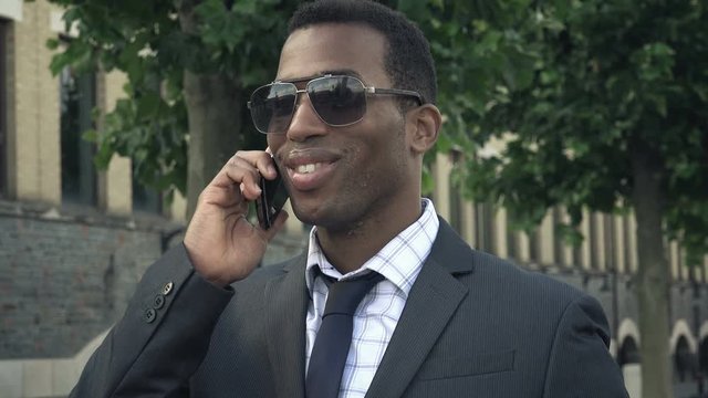 young attractive african american businessman using smartphone in the city