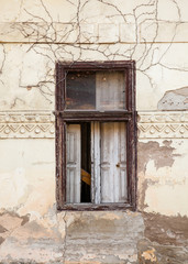 dilapidated window on the cracked wall