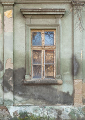 dilapidated window on the old hobbled home