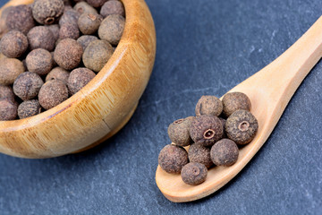 Allspice in a spoon and bowl