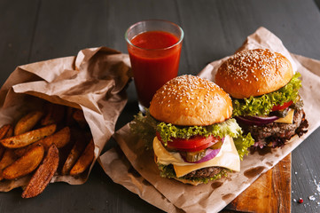 Two mouth-watering, delicious homemade burger used to chop beef. on the wooden table.