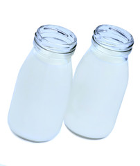 Glass milk bottles on white background