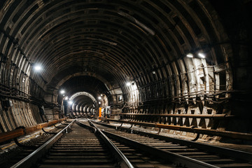 Straight circular subway tunnel connected to the other tunnel with tubing and white lights.