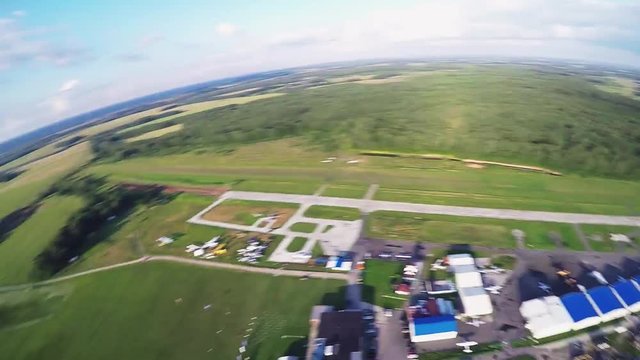 Professional skydiver fly on parachute landing on special field. Sunny day. Extreme sport