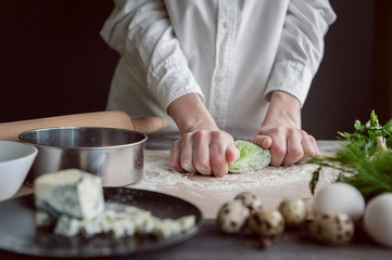 Obraz na płótnie Canvas woman kneads dough for ravioli