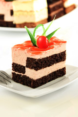 Delicious cake with brown and pink layers and cherry on the top