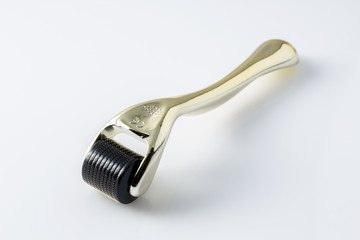 Golden derma roller for medical micro needling therapy. Tool also known as: Derma roller, mesoroller, meso-roller, mesopen.