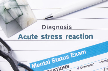 Psychiatric Diagnosis Acute Stress Reaction. Medical book or form with the name of diagnosis Acute Stress Reaction is on table of doctor surrounded by questionnaire to determine mental state