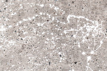 Texture of stained gray concrete with spots of white paint