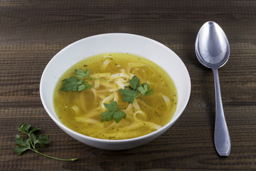 Chicken broth with noodles and parsley leaves. Traditional polish soup.