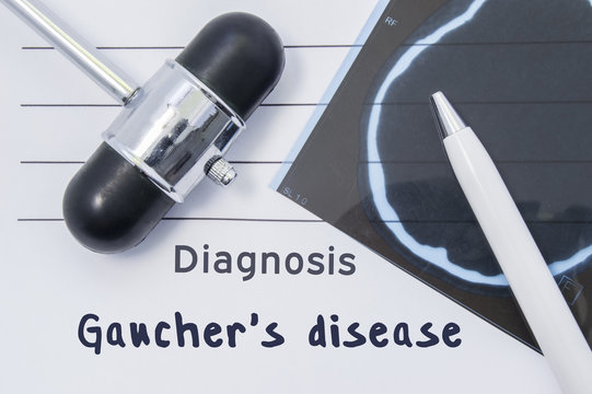 Diagnosis Gaucher disease. Written medical report, which indicated neurological diagnosis Gaucher disease, surrounded by MRI of brain and reflex hammer on desk in doctor neurologist office