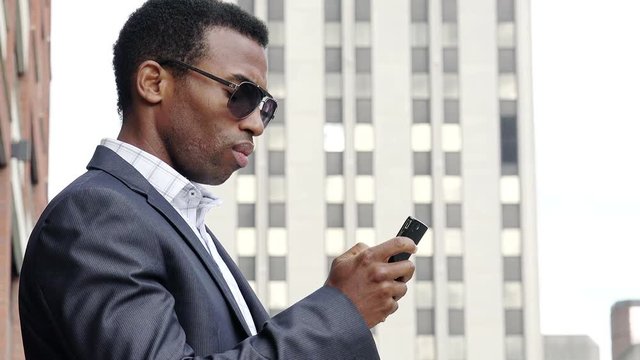 young handsome businessman using cell phone or smartphone in the city