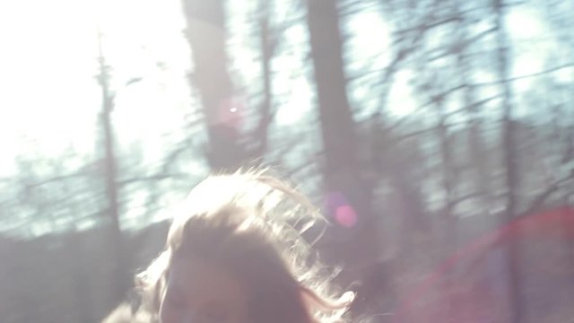 Young beautiful blonde girl have fun at the autumn sunny wood smiling and run