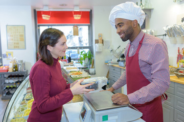 Obraz premium shopkeeper gives pastry to woman