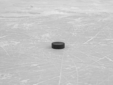 Hockey puck on ice hockey rink, selective focus