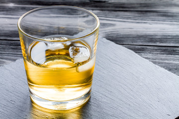 glass of whiskey on dark wooden background