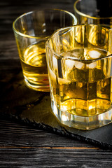 glass of whiskey on dark wooden background