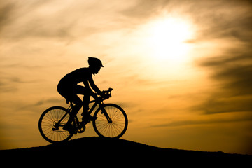 Fototapeta na wymiar Silhouette of man with bicycle at sunset