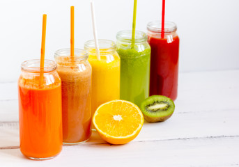 Fresh detox juices glass in row bottles on white background