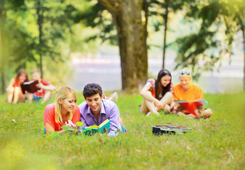 pair successful students with a textbook in a Park on a Sunny day