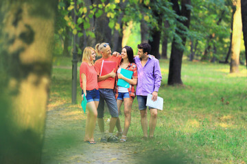 Fototapeta premium group of happy students with books in the Park on a Sunny day.