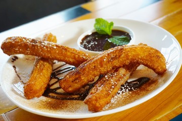 Plate of fried churro with sugar and chocolate dipping sauce
