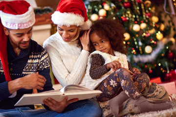 Fototapeta na wymiar Afro American family look at book for Christmas
