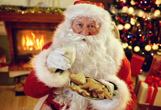 Santa Claus enjoying in cookies and milk.