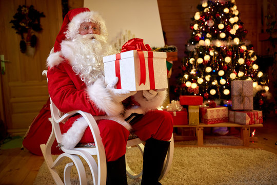 Santa Claus with big gift in arms