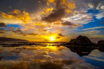 Beautiful Hawaiian sunset reflected in tide pool on the North Shore of Oahu
