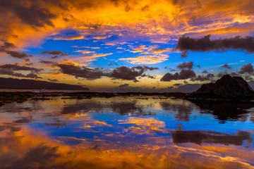 Fototapeta na wymiar Beautiful Hawaiian sunset reflected in tide pool on the North Shore of Oahu