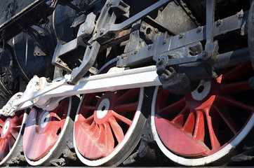 Red wheels of old USSR black steam locomotive. Wheels of an old soviet steam train