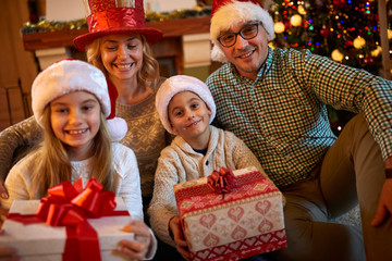 Happy family with Christmas gift at home.