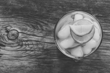 refreshing lemonade with  lemon and ice closeup top view, black and white photo