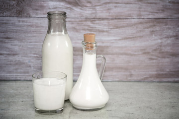 Milk in a glass. milk in a glass decanter, bottle of milk on wood background. Concept from alfaphotorus