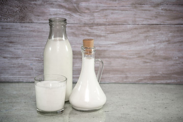 Milk in a glass. milk in a glass decanter, bottle of milk on wood background. Concept from alfaphotorus