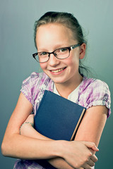 Young Girl With Glasses Smiling And Hugging Book