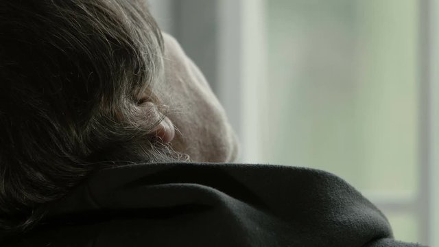 adult man takes a break of relaxation at home sitting neat the window